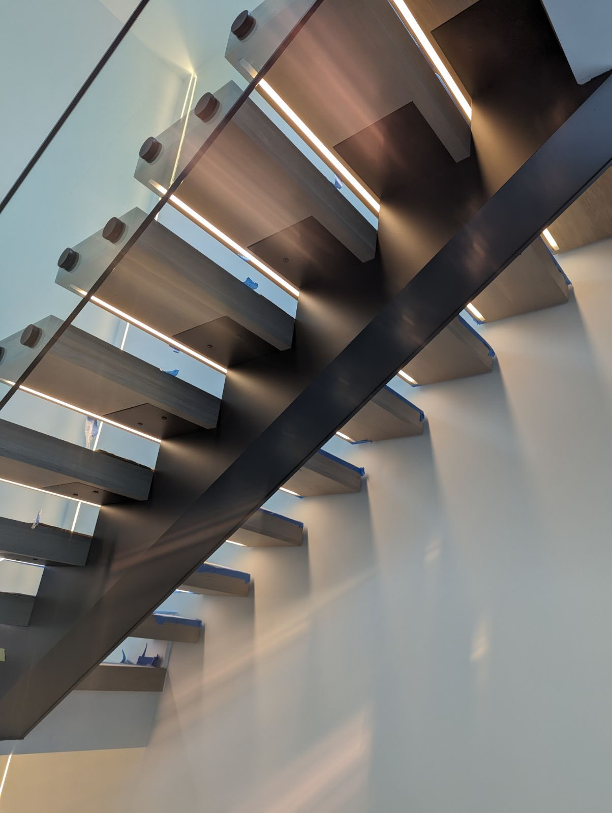 Underside of a floating staircase showing steel stringer and concealed LED lighting